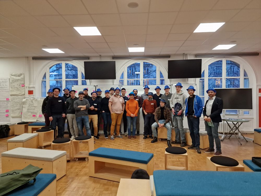 Photo montrant les participants au Garagethon avec des chapeaux bleus